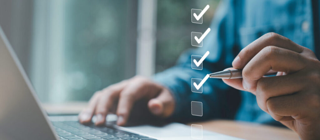 Businessman in People and Benefits Leadership using a pen to check the boxes for their managed risks.